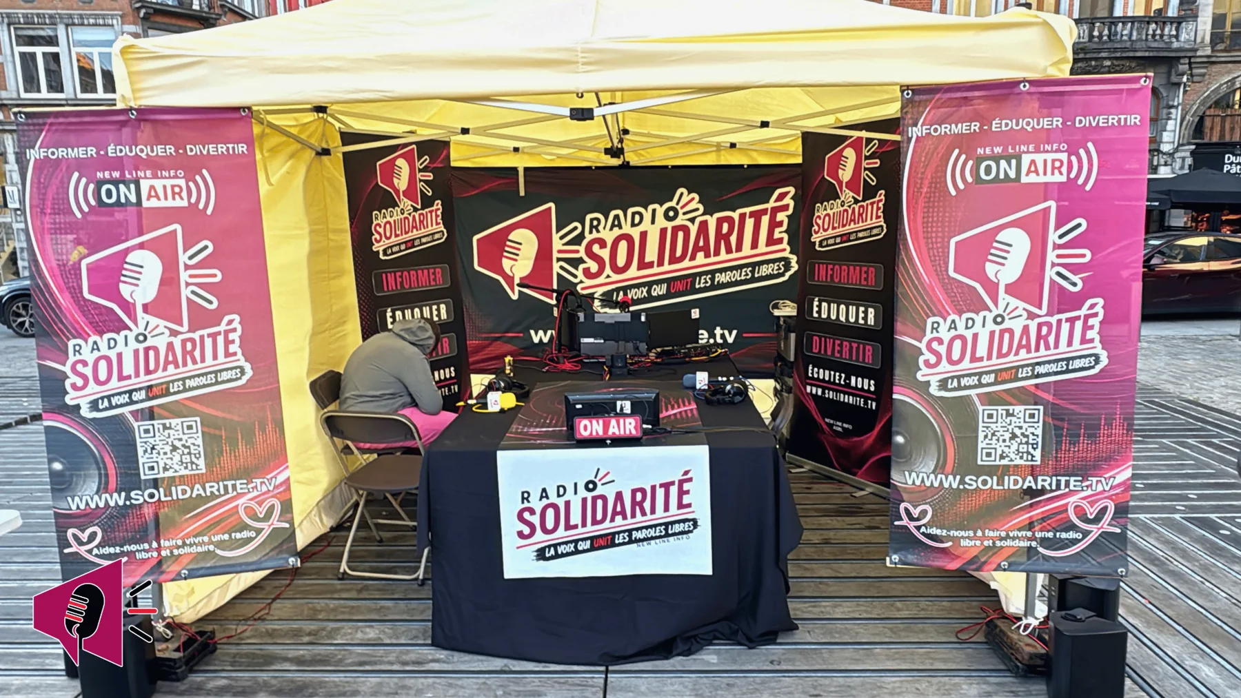 Studio radio mobile de Radio Solidarité, encadré de deux banderoles et de supports de communication créés par New Line Info